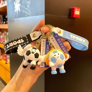 Cartoon football keychain set with wings and headphones held in hand for sports fans