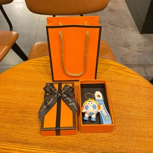 Detail view of cartoon soccer keychain in premium orange gift box with sport strap