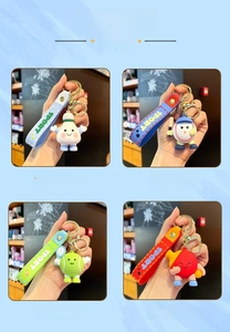 Detail of four sports-themed PVC keychains including badminton and tennis ball dolls