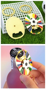 Detail of golden football keychain opener with rotating ball and enamel stripes