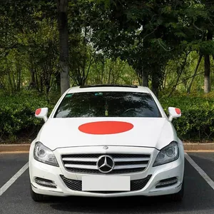 Close-up of red circular decorative car stickers on hood and side mirrors of a white car