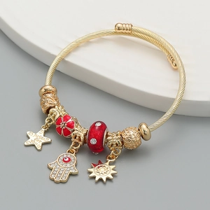 Bohemian gold twisted bangle with charms including sun, hand, flower and star pendants