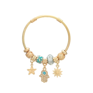 Bohemian gold bangle with star, sun, and evil eye charms featuring polished beads