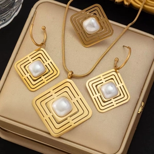 Détail de l'ensemble de bijoux géométriques dorés avec perles sur un coffret en cuir