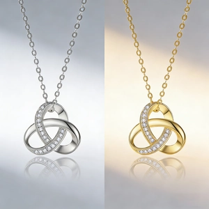 Detailed view of intertwined triple ring pendants in silver and gold with cubic zirconia