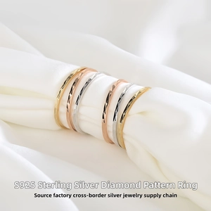 Detailed macro view of S925 sterling silver rings with diamond-cut patterns on silk