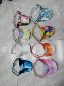 Top view of eight tie-dye open-top sun visors with adjustable closures in various colors