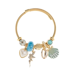 Golden mesh bracelet with heart pearl charms sea shell and angel pendant on white background