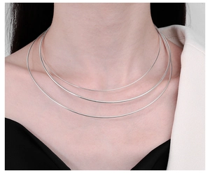 Close-up of a three-layer S925 sterling silver snake bone chain necklace on a model