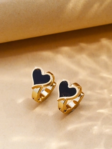 Macro shot of gold double-layered heart hoop earrings with black enamel inlay details