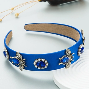Macro view of blue velvet headband with crystal jewels and gold bee ornaments