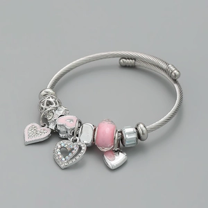 Detail of a Pandora-style bracelet with pink enamel hearts and glass beads on silver wire