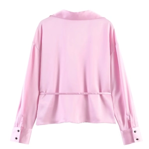 Rear view of pink satin shirt featuring spread collar and button cuffs with belt detail