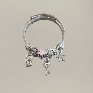 Silver charm bracelet with pink star padlock and key charms on a textured band