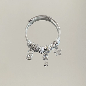 Detail view of silver stainless steel charm bracelet with star key lock charms and beads