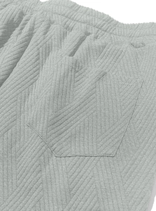 Macro shot of grey jacquard knitted shorts featuring elastic waistband and back pocket
