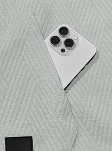 Detail of light gray knit fabric texture with functional pocket and leather patch