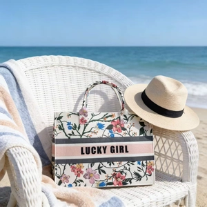 Detail of floral canvas tote bag with triple stripe and Lucky Girl text on beach chair