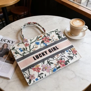 Detailed embroidery of floral pattern and Lucky Girl logo on canvas tote bag