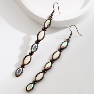 Détail de boucles d'oreilles pendantes vintage en bronze avec pierres et strass