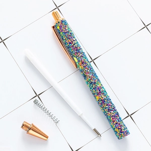 Glitter ballpoint pen with gold clip shown with disassembled metal parts and refill