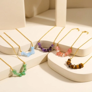 Detail shot of five natural irregular stone necklaces on gold stainless steel chains