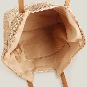 Large woven tote bag featuring a spacious interior with zip pocket and leather handles