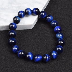 Deep blue tiger eye beaded bracelet with natural cat-eye effect on black matte background