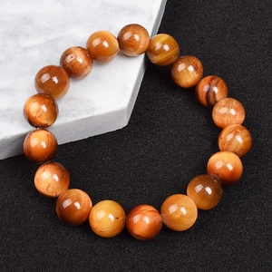 Macro view of 8mm red tiger eye stone beads with natural chatoyancy effect