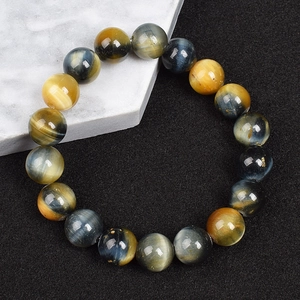 Macro shot of 8mm tiger eye stone beads with natural texture on a marble base