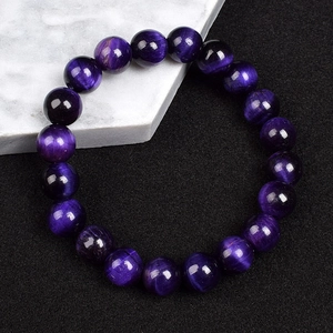 Macro detail of 8mm purple tiger eye beads showing natural fibrous texture and high gloss