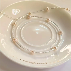 Elegant S925 silver necklace featuring round pearls and textured silver beads on ceramic dish