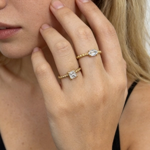 Close-up of 18K gold plated beaded rings with oval and square zircon stones on finger