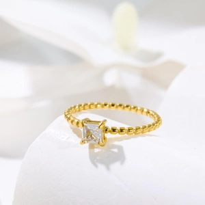 18K gold plated beaded ring featuring a square-cut zirconia on a white stone base