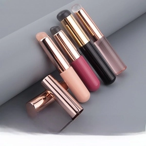 Close-up of portable silicone lip brushes with rose gold metal ferrules in multiple colors