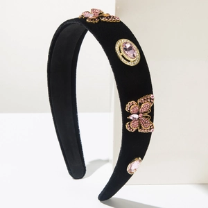 Detailed macro of velvet headband featuring pink crystal butterfly and gemstone embellishments