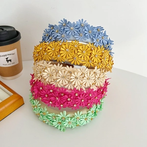 Detailed top view of colorful floral headbands with small 3D daisies and rhinestones