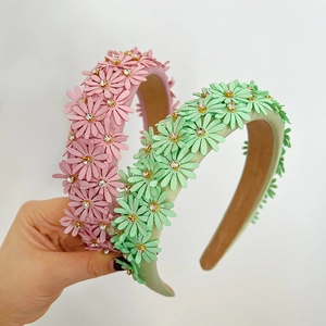 Handcrafted floral headband with pink and green daisy petals and sparkling rhinestones