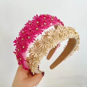 Detailed macro view of 3D fabric daisies and sparkling rhinestones on padded headbands