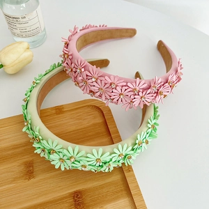 Detail of floral headbands with 3D petals and sparkling rhinestones on wood