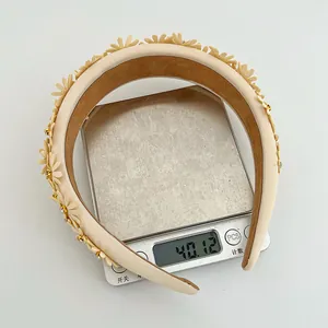 Detail of beige floral headband weighing 40g on digital scale showing lightweight quality