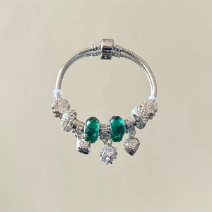 Bracciale con ciondoli, perle di vetro verde e pendenti a forma di cuore argentati