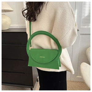 Detailansicht der hellgrünen Handtasche mit Ringgriff und modischem Logo-Schriftzug