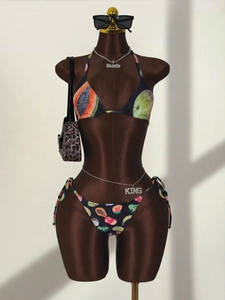 Detail of three-piece bikini set featuring vibrant tropical fruit print on black fabric