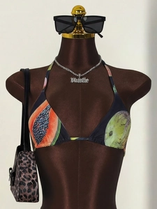 Detail of halter bikini top with vibrant tropical papaya and melon fruit print design