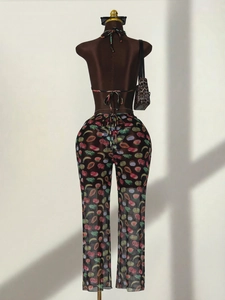 Three-piece bikini set with tropical fruit print and sheer cover-up pants on mannequin