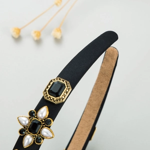 Close-up of vintage headband detail with black gemstone and pearl flower decor