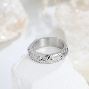 Detail of silver sun and moon embossed ring with star patterns and zircon on mineral stone