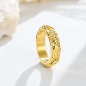 Detail of celestial gold ring featuring embossed sun, moon, stars and zircon accents