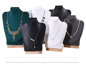 Close-up of necklace bust displays in multi-color velvet finishes and wooden bases